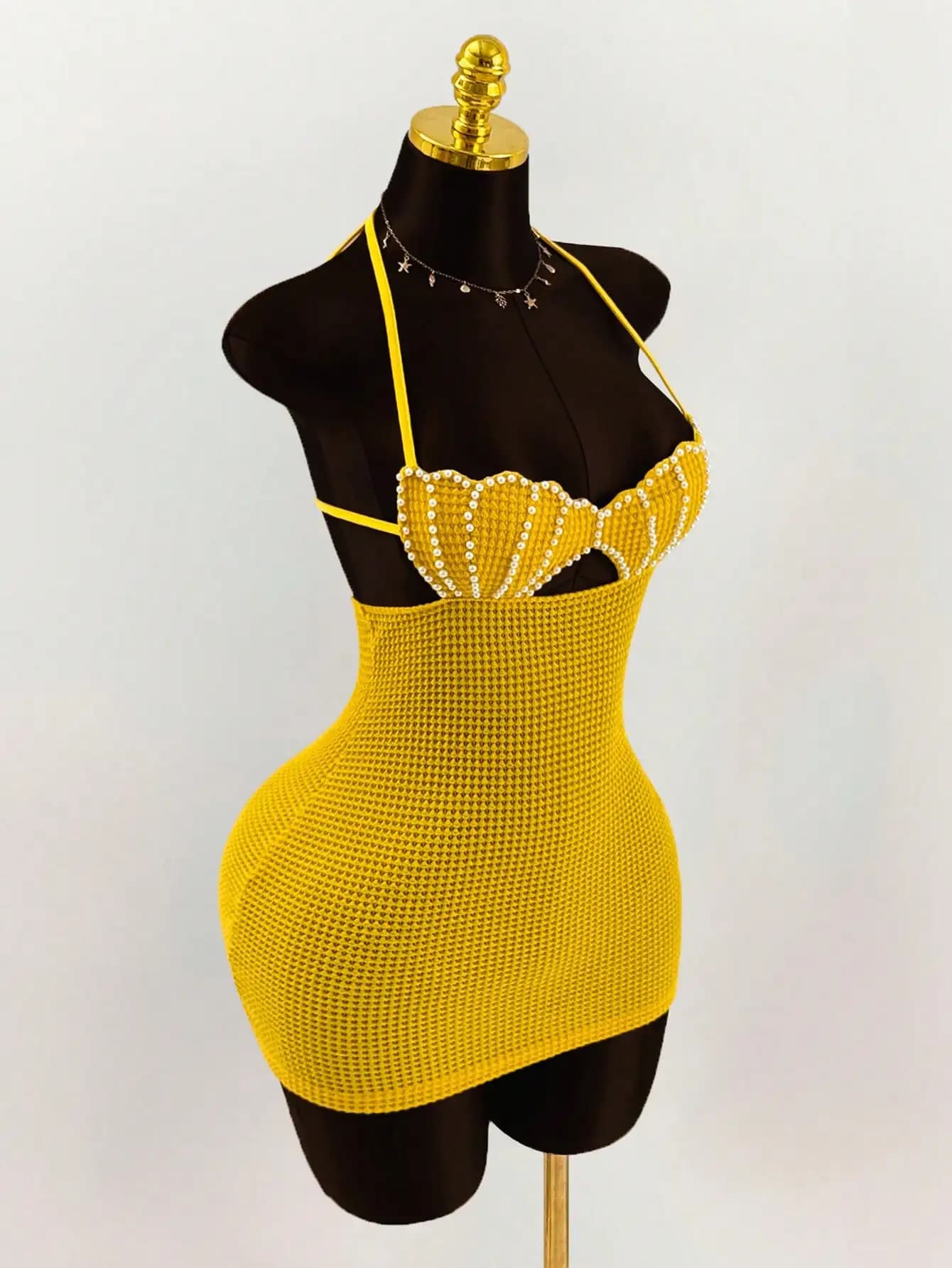 Robe mini moulante dos nu en crochet style bikini, ornée de perles et de coquillages